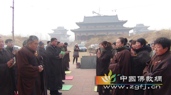 居士们在临时的大殿前虔诚诵经